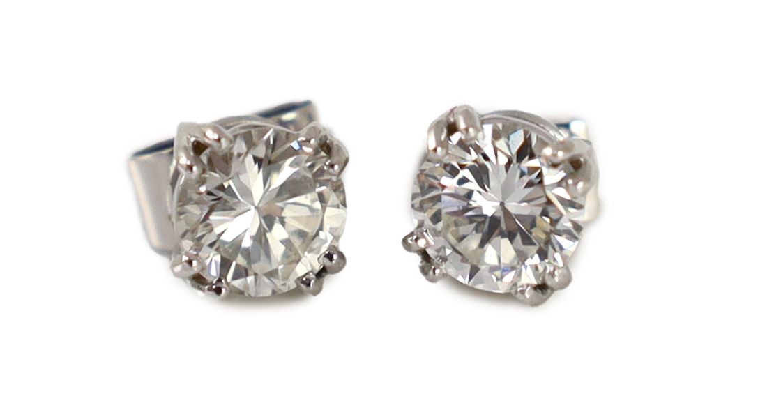 A pair of white gold and solitaire diamond set ear studs